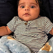 Ansh joined the competition — help win amazing prizes! baby, child, blanket, teddy_bear, striped_shirt, blue_blanket, face, eyes, infant, cute, cozy, portrait, cushion, clothing, person, young_child, indoor, soft, expression, sleepwear