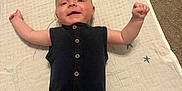 Grayson joined the competition — help win amazing prizes! baby, infant, black_romper, blanket, stars, carpet, smiling, arms_up, lying_down, cute, child, indoor, young, happy, person, buttoned_clothing, head, face, skin, expression