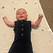 Grayson joined the competition — help win amazing prizes! baby, infant, black_romper, blanket, stars, carpet, smiling, arms_up, lying_down, cute, child, indoor, young, happy, person, buttoned_clothing, head, face, skin, expression