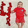 Samuel is registered to the contest to win money with this photo: baby, infant, red_stripes, mickey_mouse, rose_petals, letter_y, white_blanket, smiling, lying_down, cute, child, portrait, soft_texture, happy, indoor, small_hands, small_feet, bright, colorful, patterned_clothing