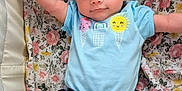 Line is registered to the contest to win money with this photo: arms_outstretched, baby, blue_bow, child, cozy, cute, face, floral_blanket, happy, headband, ice_cream_print, indoors, infant, light_blue_shirt, lying_down, pants, portrait, smiling, soft_lighting, young_child