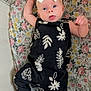 Line is registered to the contest to win money with this photo: baby, infant, child, headband, bow, blue_eyes, floral_blanket, black_outfit, white_prints, lying_down, cute, portrait, indoors, soft_lighting, small_hands, small_feet, expression, fabric, comfort, resting