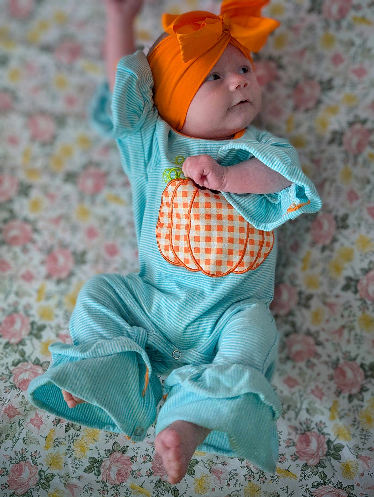 Line joined the competition — help win amazing prizes! baby, infant, child, blue_onesie, orange_headband, bow, pumpkin_applique, striped_clothing, floral_blanket, lying_down, barefoot, cute, curious, portrait, indoors, soft_lighting, smiling, small_hand, small_foot, comfortable