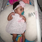 Alina Ebanks is registered to the contest to win money with this photo: baby, infant, pink_dress, headband, pacifier, baby_nest, soft_toy, colorful_bedding, cute, child, lying_down, indoor, portrait, sleepwear, newborn, baby_accessories, resting, young_child, adorable, baby_girl