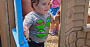 Aaron is registered to the contest to win money with this photo: backyard, barefoot, child, children, curious, doorway, family, greenery, outdoor, plastic, playground, playhouse, shorts, smiling, standing, summer, sunlight, t_shirt, toddler, walking