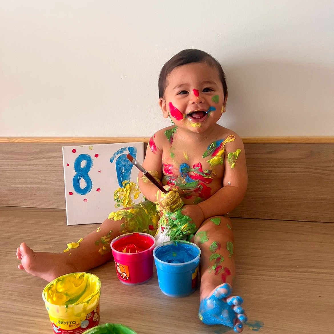 Noham participe au concours pour gagner de l'argent avec cette photo : art, baby, barefoot, blue_paint, canvas, child, colorful, creative, floor, green_paint, happy, indoor, messy, paint, paintbrush, playful, red_paint, smiling, wooden_floor, yellow_paint