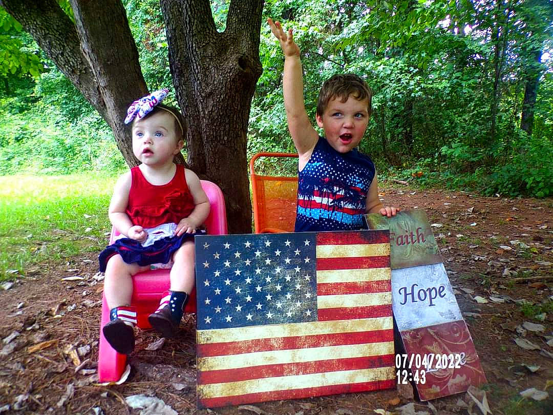 Elizabeth Grace joined the competition — help win amazing prizes! adaptation, baby_toddler_clothing, boot, child, event, face, flag_of_the_united_states, fun, garden, grass, green, leisure, people_in_nature, person, plant, recreation, sitting, soil, surprise, t_shirt