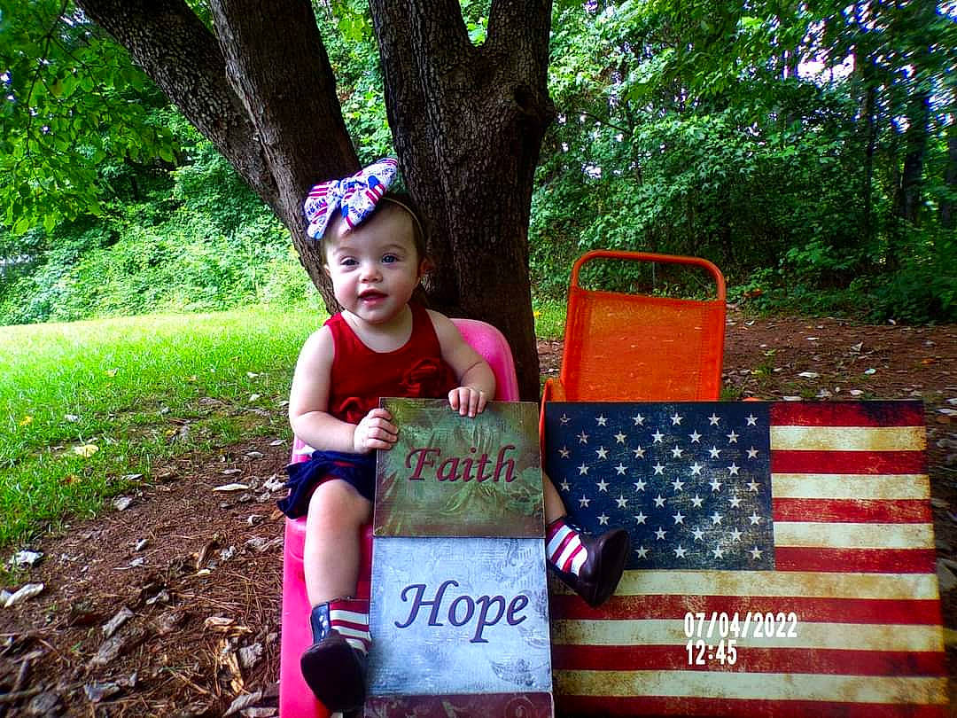 Elizabeth Grace joined the competition — help win amazing prizes! baby_toddler_clothing, flag_of_the_united_states, fun, garden, grass, green, handwriting, happy, hat, leisure, magenta, person, pink, plant, recreation, shorts, sitting, smile, t_shirt, toddler