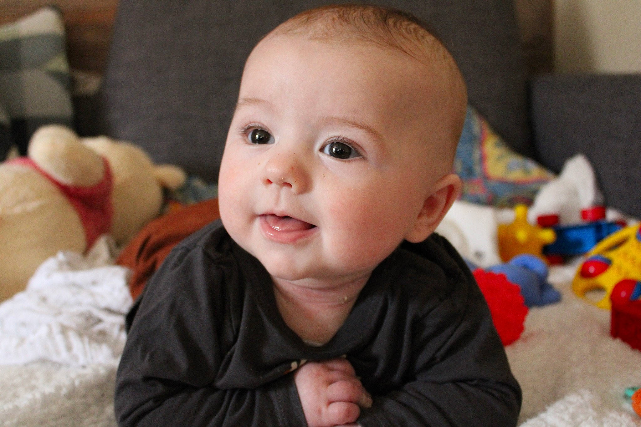 Léon participe au concours pour gagner de l'argent avec cette photo : baby, baby_toddler_clothing, cheek, child, event, flooring, fun, happy, human_body, laugh, nose, people, person, room, sitting, skin, smile, stuffed_toy, toddler, toy