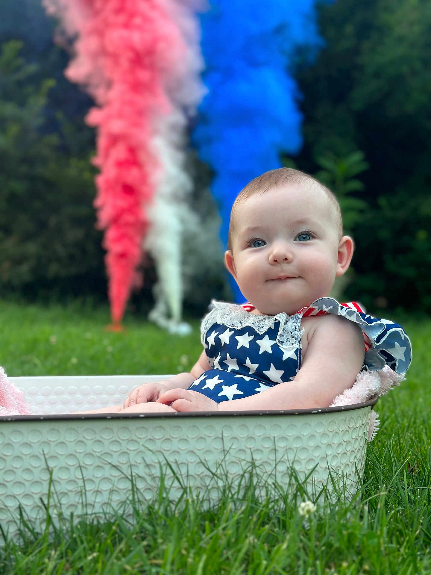 Saphira joined the competition — help win amazing prizes! baby, child, grass, outdoor, tub, blue_smoke, red_smoke, white_smoke, stars, dress, patriotic, cute, portrait, nature, greenery, summer, smile, sitting, fun, celebration