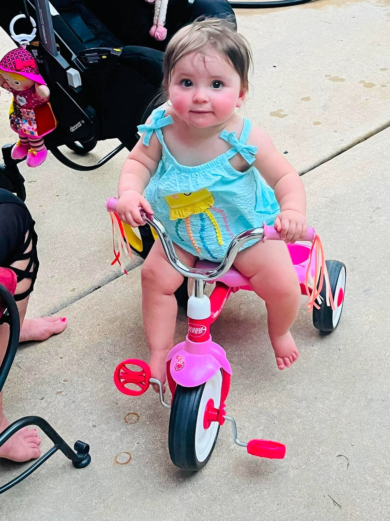 Vivian is registered to the contest to win money with this photo: baby_toddler_clothing, bicycle, bicycles_equipment_and_supplies, child, dress, fun, happy, leg, magenta, person, photograph, pink, product, public_space, riding_toy, smile, tire, toddler, vehicle, wheel