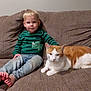 Chloe is registered to the contest to win money with this photo: toddler, child, cat, orange_cat, white_cat, couch, indoor, casual_clothing, striped_shirt, jeans, barefoot, relaxed, pet, domestic_animal, feline, human, seated, living_room, cute, cozy