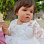 toddler, child, white_dress, lace, leaf, tree, outdoor, nature, greenery, portrait, young_child, curious, person, summer, daylight, expression, short_hair, cute, innocence, holding