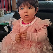 Danny participe au concours pour gagner de l'argent avec cette photo : toddler, child, pink_dress, butterfly_pattern, crown, flower_crown, indoor, living_room, sofa, curly_hair, cute, portrait, seated, curious_expression, decor, window, furniture, baby, soft_lighting, person