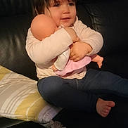 Danny participe au concours pour gagner de l'argent avec cette photo : baby_doll, casual, child, clothing, comfort, couch, doll, face, foot, hair, hugging, indoor, leisure, person, pillow, seated, smile, sofa, toddler, toy