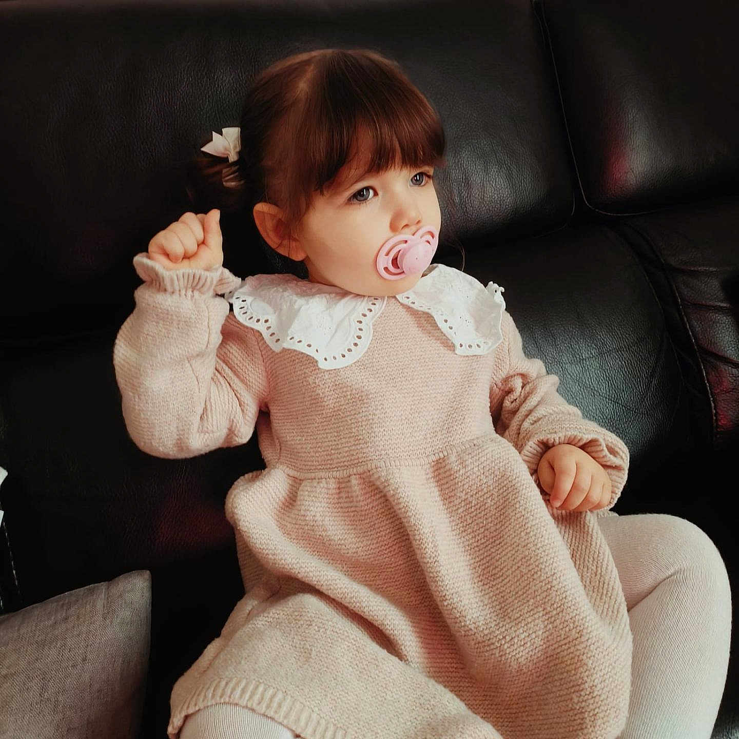 Danny a rejoint le concours — aidez-le/la à gagner de superbes lots ! black_couch, bow, child, couch, cozy, cute, girl, hair, indoors, leather, pacifier, pink_dress, portrait, relaxed, sitting, toddler, warm_clothing, white_collar, white_tights, young_child