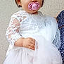 toddler, child, baby, dress, white_dress, lace, pacifier, pink_pacifier, face, blue_eyes, hand, person, portrait, cute, young_child, holding, fabric, tulle, short_hair, indoor