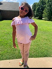 Amiya is registered to the contest to win money with this photo: arm, child, clothing, eyewear, fashion, finger, footwear, glasses, grass, joint, joy, person, photography, pink, shoe, shoulder, sleeve, style, sunglasses, t_shirt