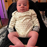 August joined the competition — help win amazing prizes! baby, infant, person, clothing, onesie, mittens, legs, feet, face, indoor, home, carpet, furniture, relaxing, sitting, looking, cute, newborn, human, casual