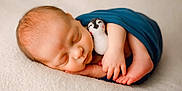 Ryker is registered to the contest to win money with this photo: baby, blanket, child, close_up, cozy, cute, foot, hand, indoors, infant, newborn, peaceful, penguin, plush_toy, portrait, resting, skin, sleeping, soft_texture, wrapped