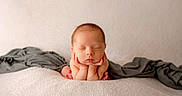 Ryker joined the competition — help win amazing prizes! baby, blanket, cheeks, closeup, cozy, hands_under_chin, head, infant, neutral_background, newborn, peaceful, portrait, resting, skin, sleeping, small_feet, soft_texture, studio_shot, toes, wrapped