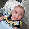 baby, child, high_chair, bib, striped_clothing, blue_eyes, smile, indoor, person, face, infant, cute, happy, furniture, wood_floor, door, home, expression, young, curious