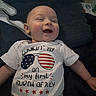 baby, infant, smiling, onesie, clothing, lying_down, blanket, crib, face, happy, celebration, holiday, fourth_of_july, flag, stars, red, white, blue, portrait, child