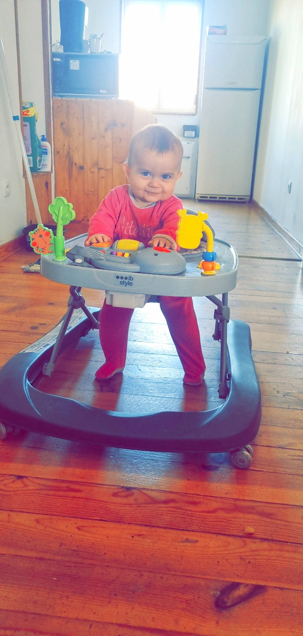 Camélya a rejoint le concours — aidez-le/la à gagner de superbes lots ! baby, baby_playing_with_toys, baby_products, baby_toddler_clothing, child, door, electric_blue, face, floor, flooring, hardwood, head, orange, person, plucked_string_instruments, string_instrument, table, toddler, toy, wood