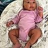 baby, infant, onesie, pink_clothing, blanket, patterned_blanket, clouds, text_on_blanket, lying_down, curious_expression, small_hands, small_feet, indoors, soft_fabric, child, newborn, cute, portrait, resting, cozy