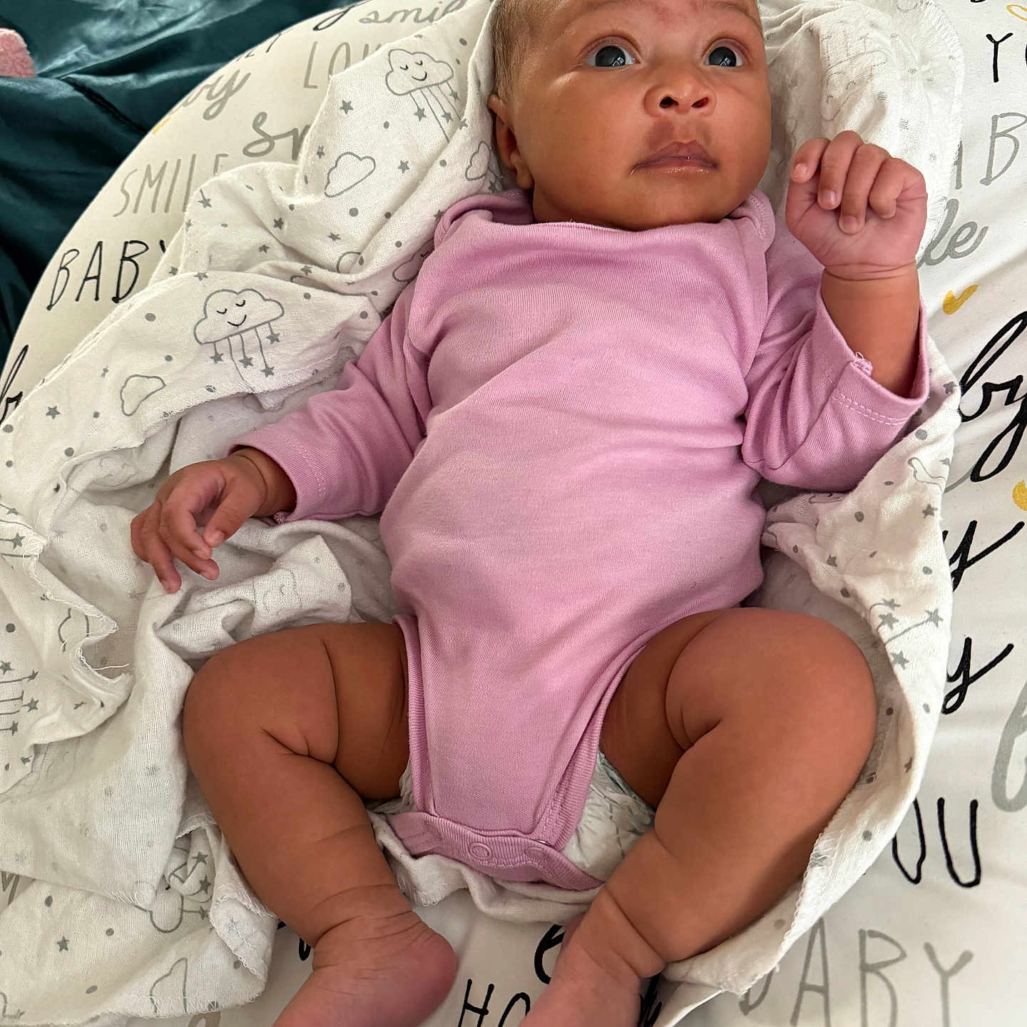 Nori joined the competition — help win amazing prizes! baby, infant, onesie, pink_clothing, blanket, patterned_blanket, clouds, text_on_blanket, lying_down, curious_expression, small_hands, small_feet, indoors, soft_fabric, child, newborn, cute, portrait, resting, cozy