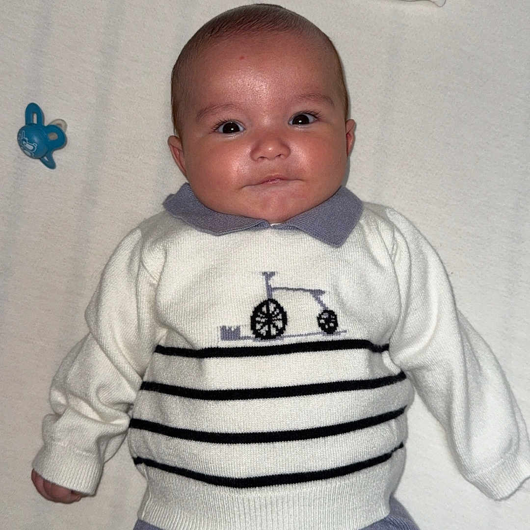 Stany participe au concours pour gagner de l'argent avec cette photo : baby, baby_toys, blanket, child, clothing, cozy, cute, eyes, face, indoor, infant, lying_down, newborn, pacifier, person, portrait, purple_pants, smile, soft, sweater