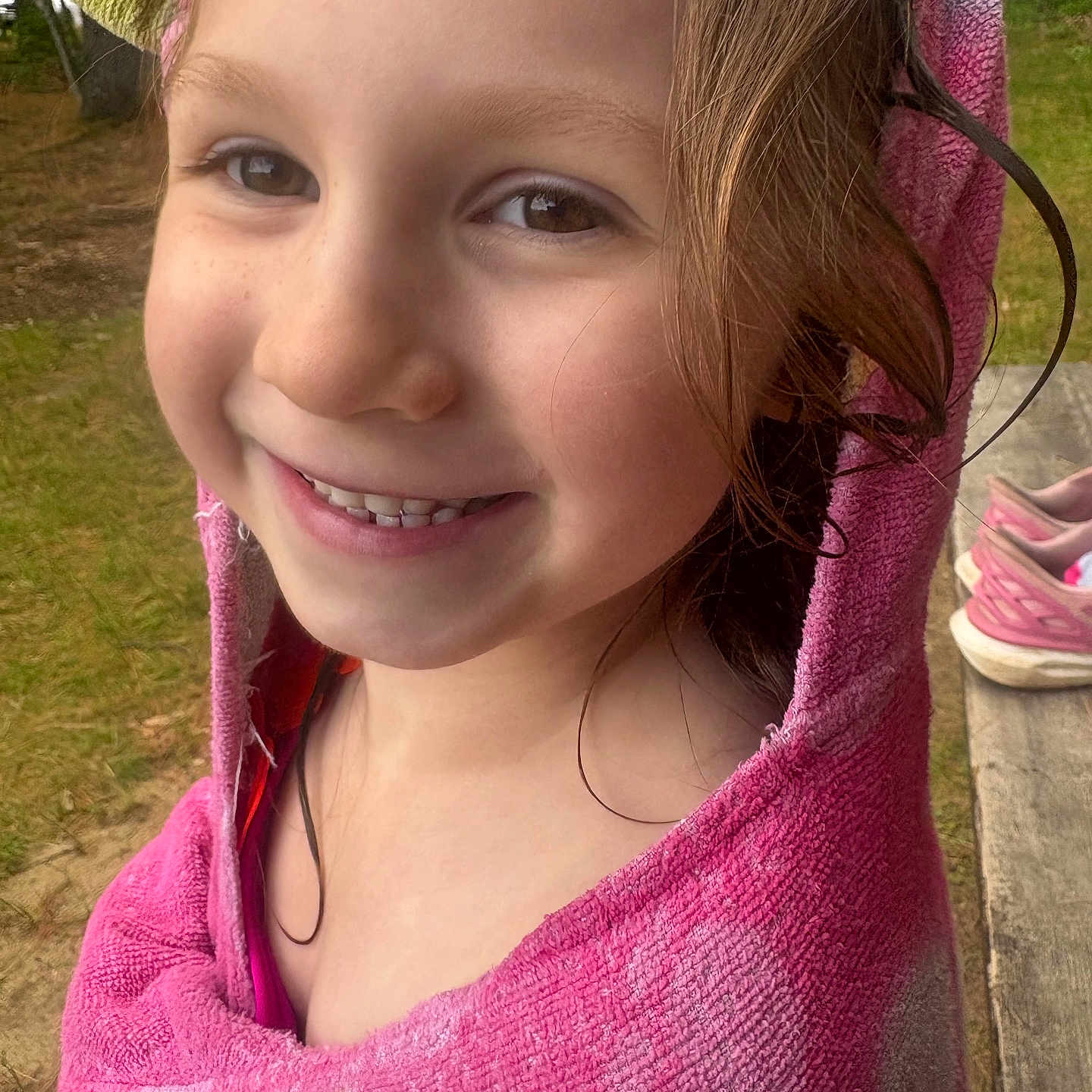 Olivia joined the competition — help win amazing prizes! bench, casual, child, closeup, face, grass, happy, head, nature, outdoor, person, pink, playful, portrait, shoes, smiling, summer, towel, wet_hair, young