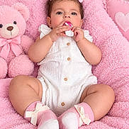 Kylie is registered to the contest to win money with this photo: baby, child, infant, portrait, smiling, sitting, pink, blanket, teddy_bear, bow, hair_bow, white_outfit, socks, cuddly_toy, nursery, indoors, soft_blanket, baby_用品, looking_at_camera, adorable