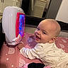 Alanna Salcedo joined the competition — help win amazing prizes! baby, infant, child, smiling, laughing, portrait, indoors, playroom, play_mat, musical_toy, glowing_toy, plush_toy, minnie_mouse, pink, white, onesie, earring, sitting, nursery, kitchen