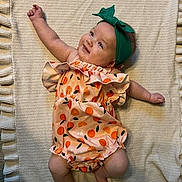 Eleonor joined the competition — help win amazing prizes! baby, infant, smiling, headband, romper, orange_pattern, blanket, laying_down, happy, cute, child, indoors, fabric, texture, skin, arm, leg, clothing, portrait, playful