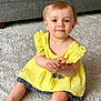 Maddy a rejoint le concours — aidez-le/la à gagner de superbes lots ! toddler, child, yellow_dress, sitting, carpet, indoor, cute, smiling, baby, person, furniture, sofa, hands, portrait, happy, skin, hair, floor, young, clothing