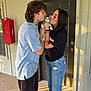 cat, kitten, couple, kiss, affection, apartment, door, sunlight, shadow, casual_clothing, bracelets, jeans, shorts, red_fire_hose, outdoor, concrete_floor, window, smiling, young_adults, pet