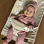 baby, infant, pink_outfit, knitwear, baby_bouncer, mesh, wooden_floor, smile, cute, hat, cozy, child, indoor, comfortable, relaxed, adorable, person, footwear, seated, baby_clothing