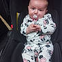 baby, infant, pacifier, car_seat, onesie, cow_print, pacifier_clip, sitting, hands, face, eyes, pink, white, black, adorable, child, portrait, clothing, strap, buckle