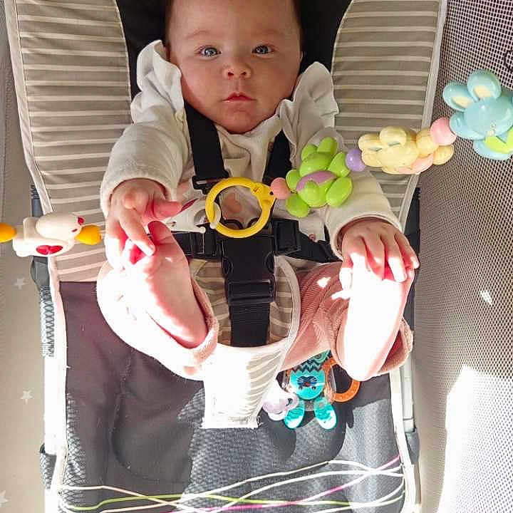 Lise a rejoint le concours — aidez-le/la à gagner de superbes lots ! baby, infant, bouncer, toy, colorful_toy, straps, cushion, curious, reaching, sunlight, indoors, clothing, foot, hand, face, child, soft_texture, playtime, seat, baby_gadget