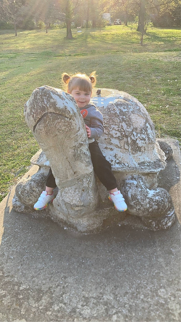 Isabella is registered to the contest to win money with this photo: art, artifact, carving, concrete, font, fun, garden, grass, grassland, joy, landscape, lawn_ornament, leisure, person, recreation, rock, sculpture, sitting, soil, statue