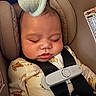 baby, sleeping, car_seat, child, pajamas, animal_print, safety_harness, infant, peaceful, cute, seatbelt, head_support, soft_toys, resting, indoors, close_up, childcare, comfort, nap, newborn