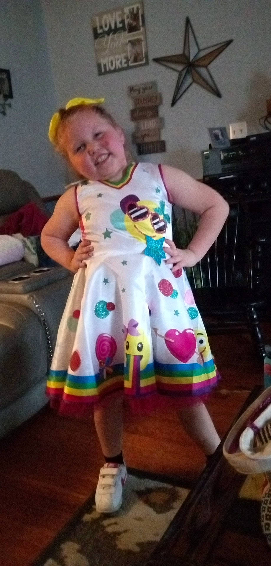 Kayleigh is registered to the contest to win money with this photo: baby_toddler_clothing, chair, child, event, face, fashion_design, fun, head, human_leg, joy, magenta, pattern, person, purple, room, sitting, sleeve, smile, t_shirt, textile