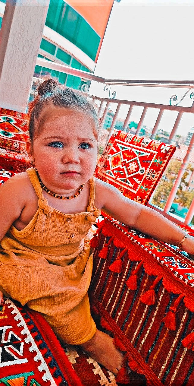 Lina participe au concours pour gagner de l'argent avec cette photo : baby_toddler_clothing, blue, chair, child, design, facial_expression, fun, hand, happy, human_body, leisure, orange, person, red, sitting, skin, standing, summer, toddler, travel