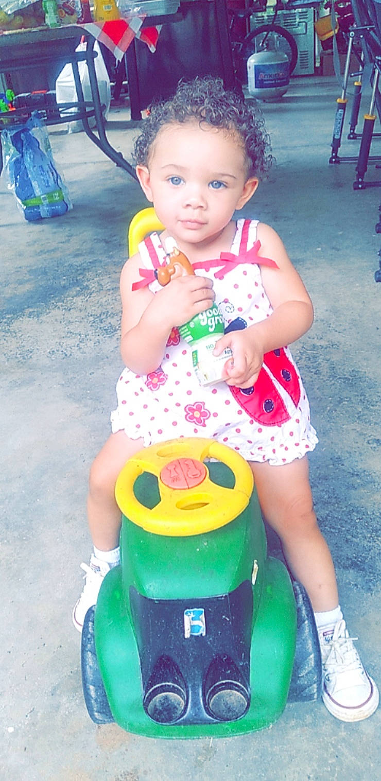 Lydia is registered to the contest to win money with this photo: baby_toddler_clothing, blue, child, dress, fun, green, happy, people, person, photograph, pink, product, public_space, riding_toy, shoe, skin, toddler, vehicle, wheel, white