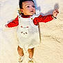 Raikishori is registered to the contest to win money with this photo: baby, infant, blanket, knitted_clothing, romper, red_shirt, socks, bow, cute, lying_down, face, expression, small_hands, small_feet, soft_texture, indoor, portrait, child, adorable, newborn