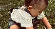 Felix is registered to the contest to win money with this photo: toddler, child, outdoor, park, grass, dandelion, flowers, nature, sitting, crouching, exploring, curious, hair, profile, shorts, t_shirt, overalls, tree, sunlight, portrait