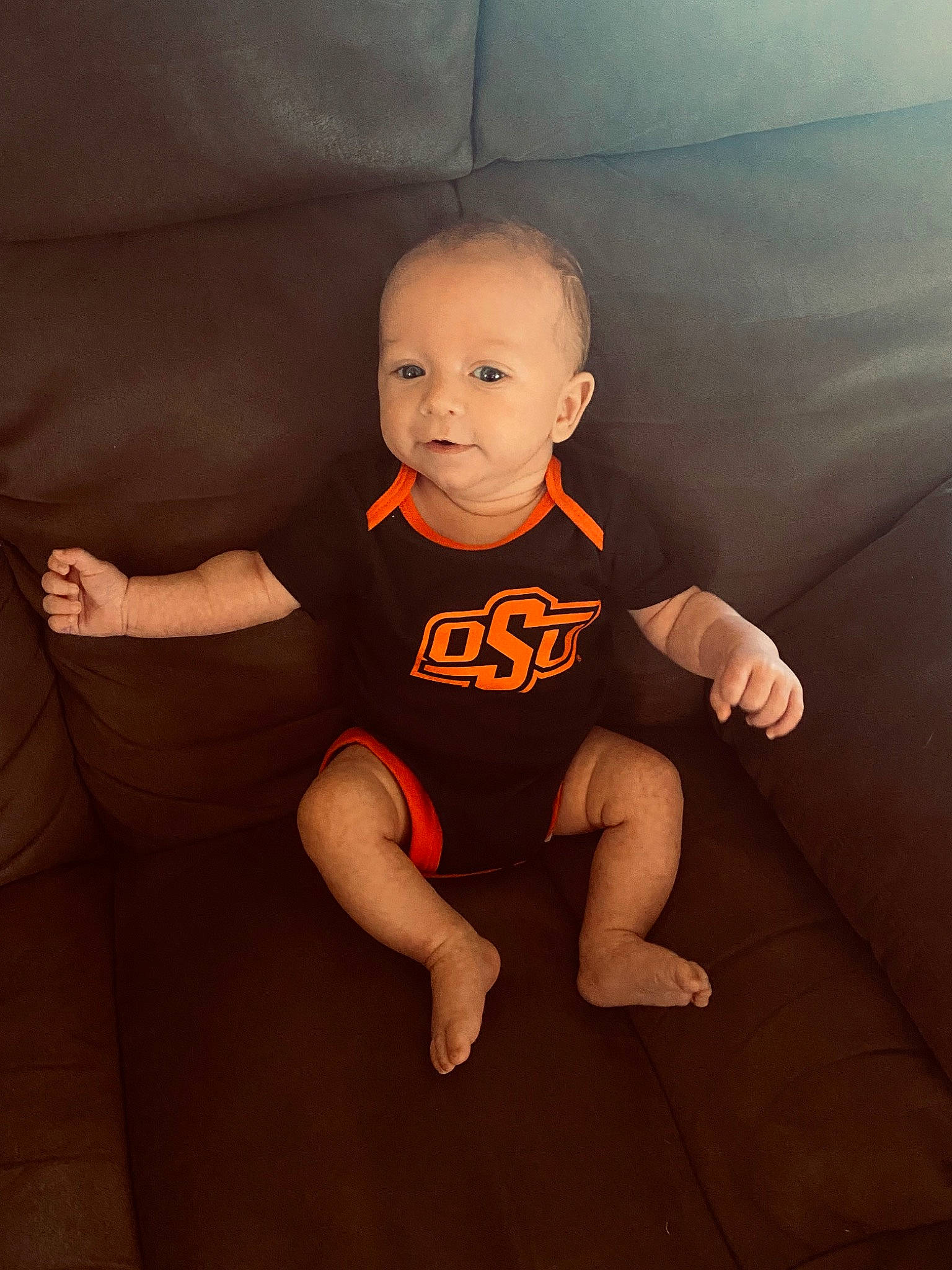 Caden is registered to the contest to win money with this photo: baby, baby_toddler_clothing, cheek, chin, finger, flash_photography, floor, flooring, joint, knee, leg, neck, orange, person, skin, sleeve, smile, t_shirt, thigh, toddler