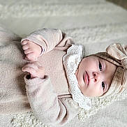 Julia participe au concours pour gagner de l'argent avec cette photo : baby, beige, blanket, bow, child, clothing, cozy, cute, eyes, face, hands, headband, indoors, infant, lace, lying_down, newborn, portrait, soft, texture