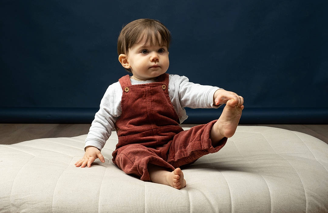 Swan participe au concours pour gagner de l'argent avec cette photo : arm, baby, baby_toddler_clothing, cheek, comfort, elbow, event, face, flash_photography, flooring, foot, fun, gesture, happy, human_leg, person, shoulder, sitting, skin, sleeve